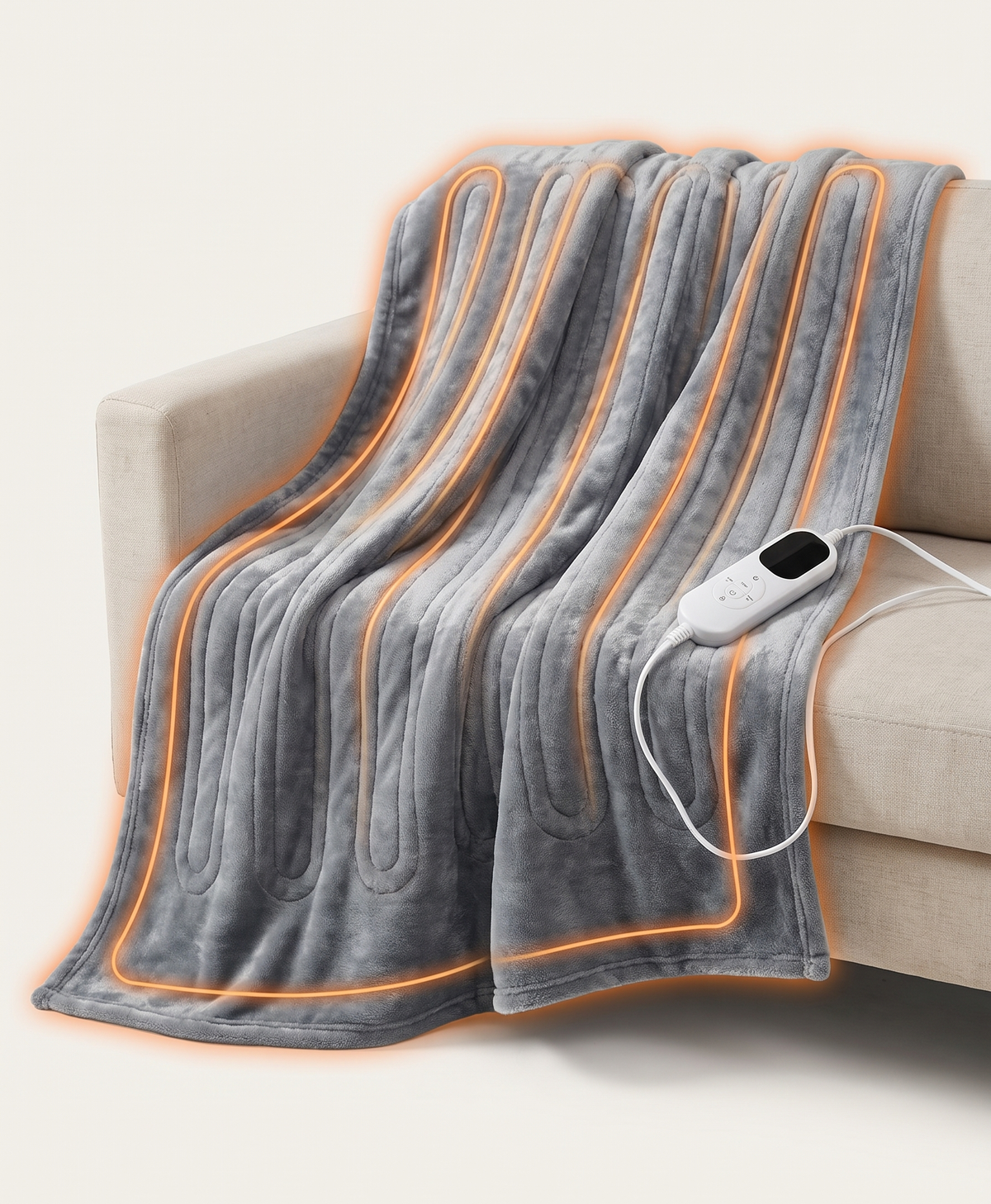 Grey electric heated blanket draped over a sofa with the heating channels glowing warm orange