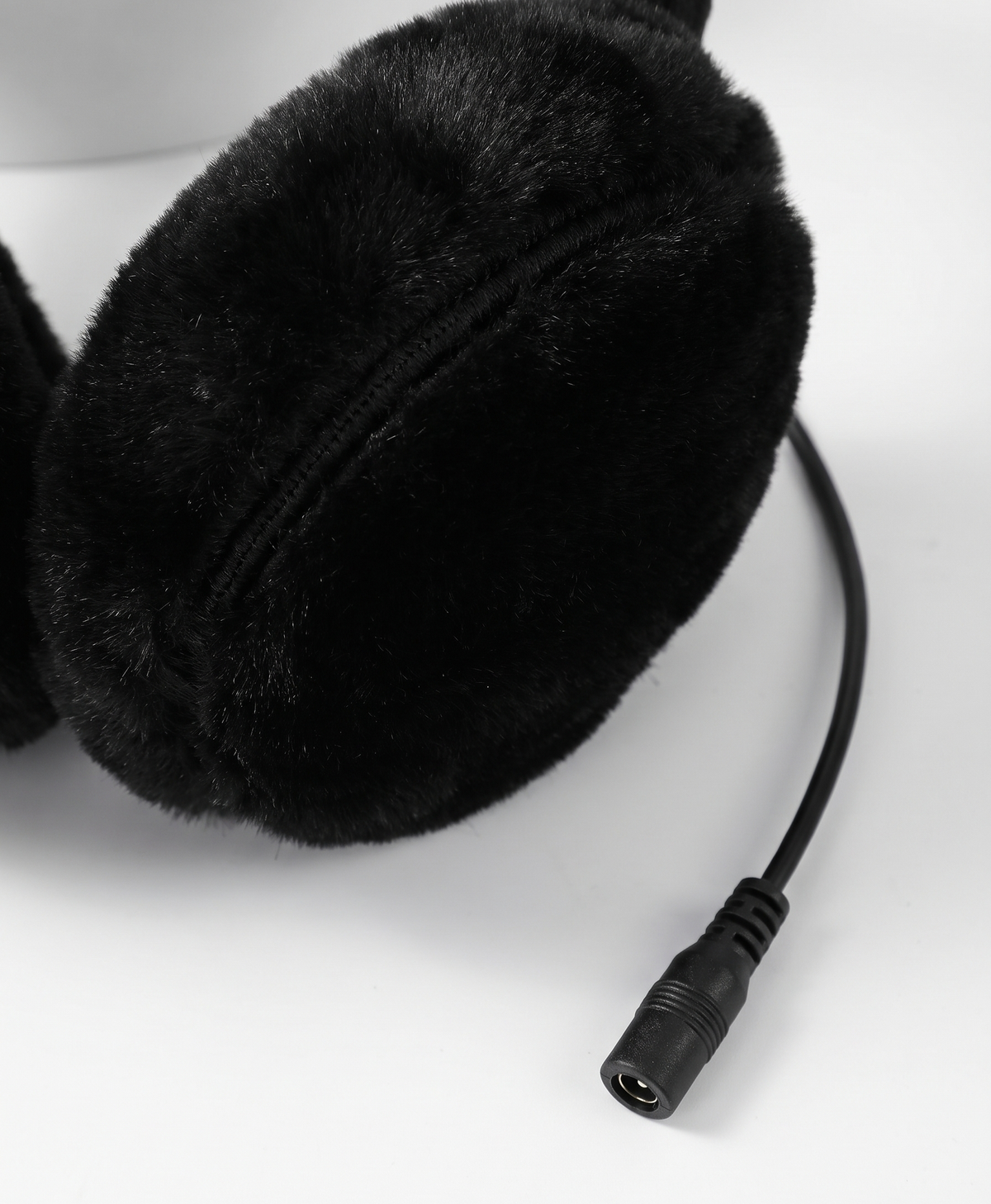 Close-up of the plush gray earmuff cups and the cable connector plugs on the heated earmuffs