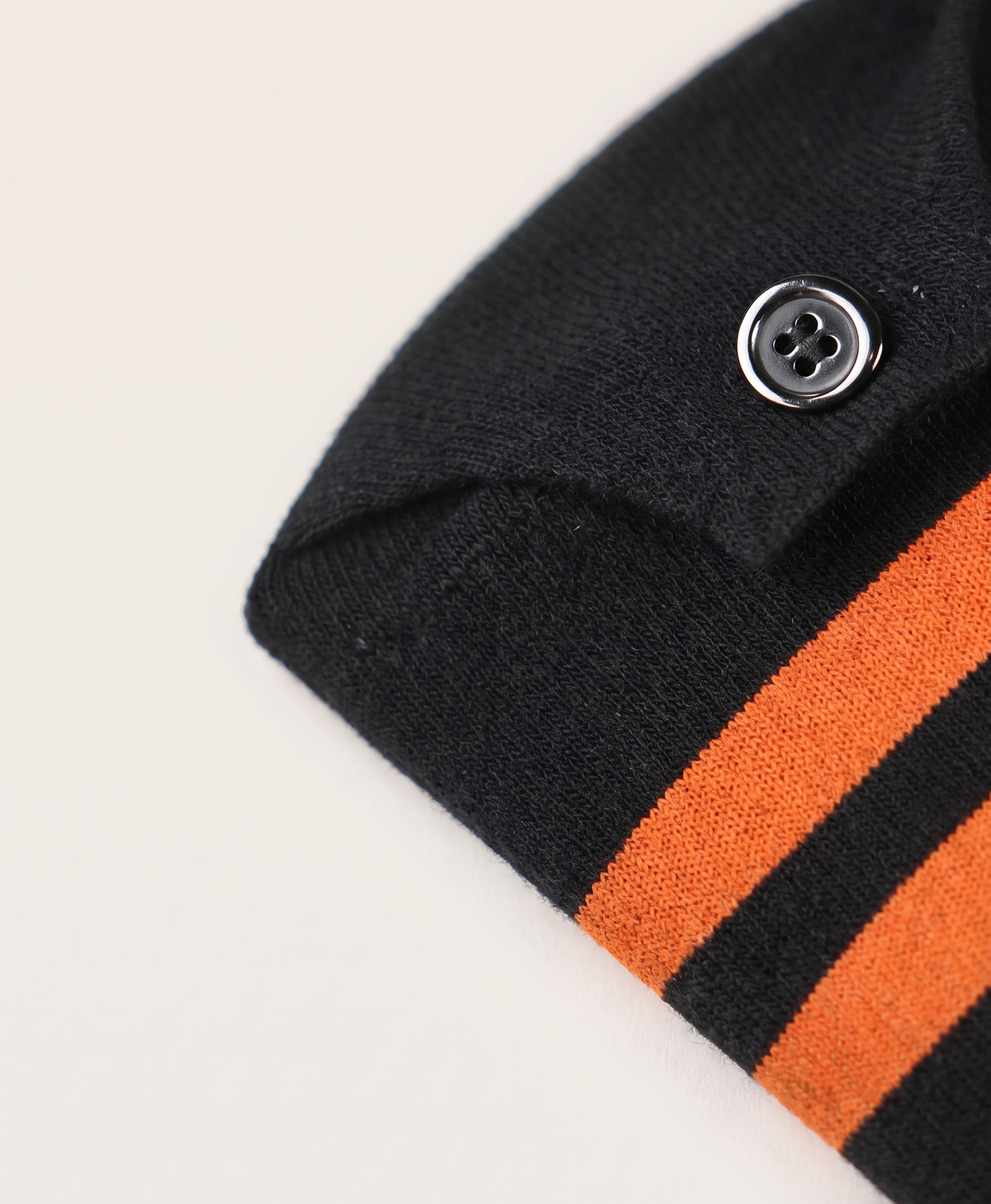Close-up of the striped cuff and button on the black heated cotton sock