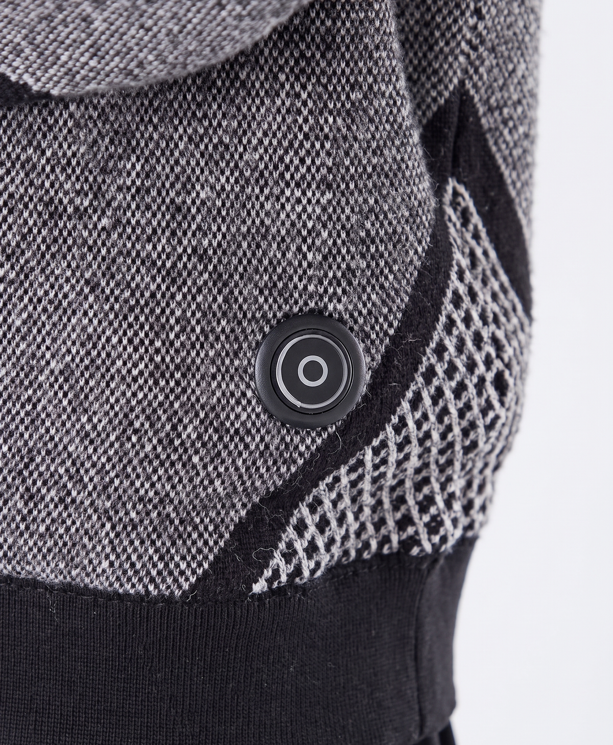Close-up of the knitted fabric, V-shaped pattern panel and ribbed cuff of the sweater