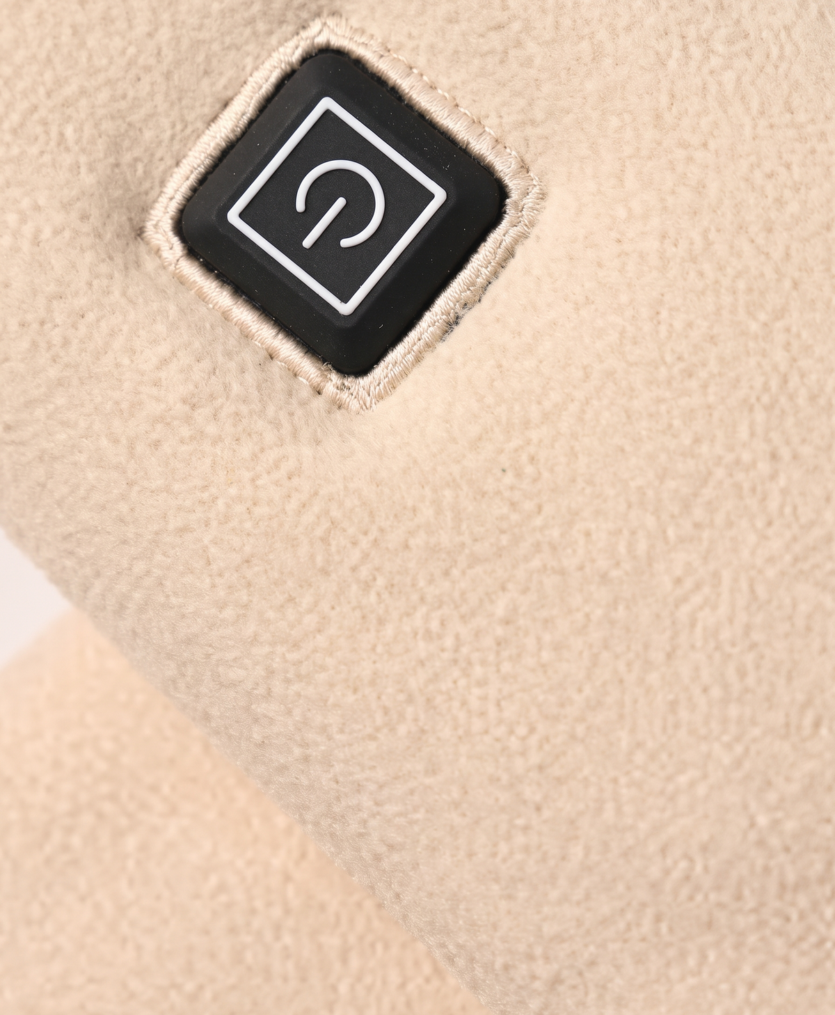 Close-up of the scarf's square power button and soft fleece fabric texture in khaki