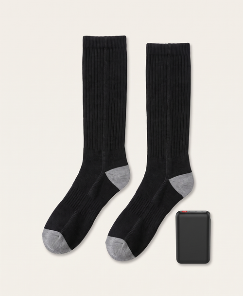 Black battery pack with red power button, shown beside the black knee-high heated socks it powers