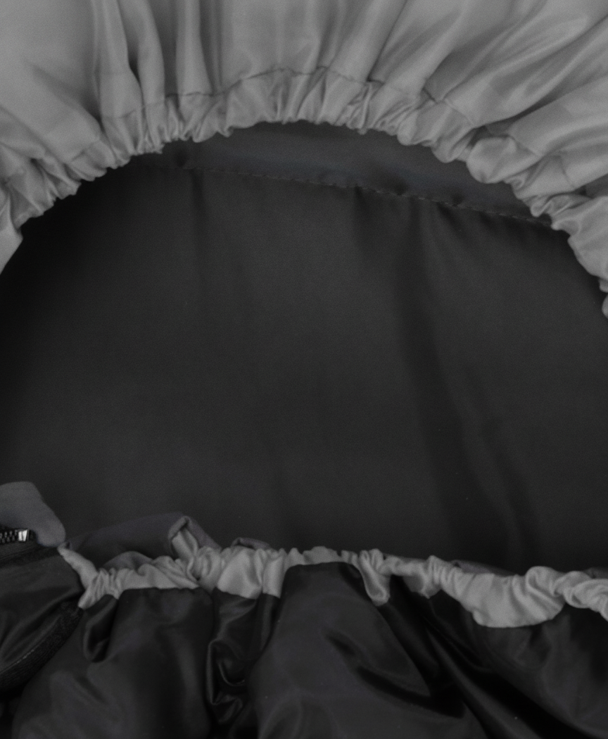 Close-up of the sleeping bag hood with adjustable drawstring and zipper, in gray with black lining