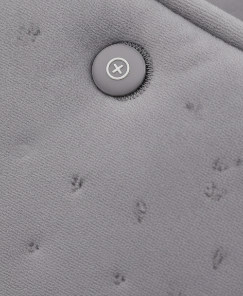 Close-up of the gray embossed soft fabric and buckles on the heated hand muff, with the USB cable attached