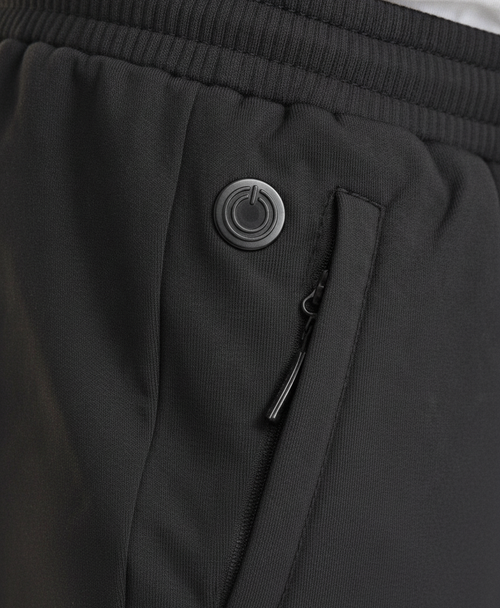 Close-up of black heated pants with elastic drawstring waistband and zippered side pocket