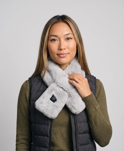 Woman wearing the Coziva heated plush faux-fur neck wrap in grey