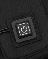 Close-up of the round power button controller on the heating pad set sewn into black fabric