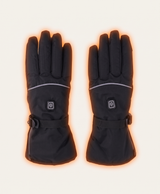 Two black heated gloves against snowy mountains showing the power button, reflective stripe and cuff strap