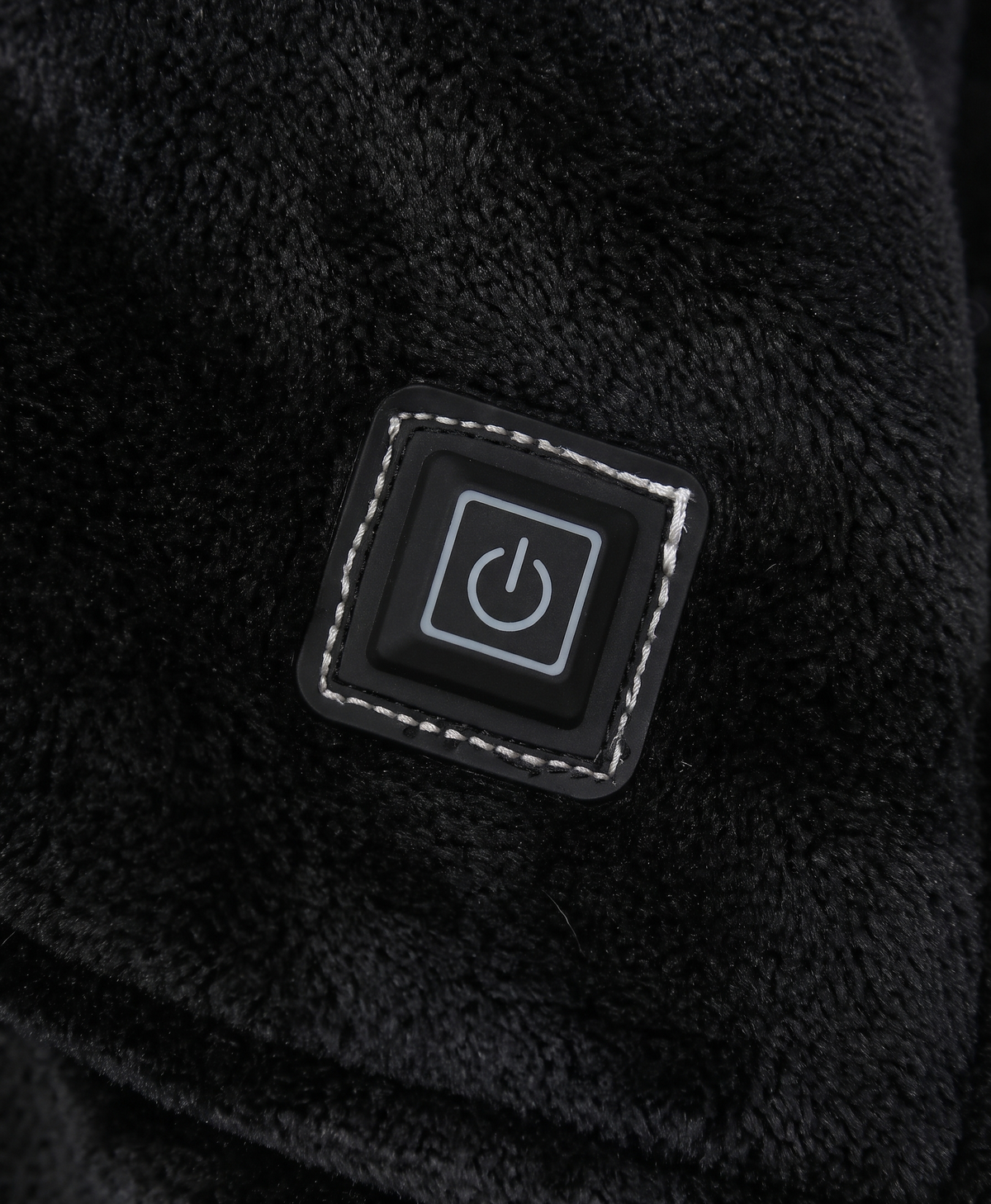 Close-up of the large front pocket and heating control button on the oversized hoodie