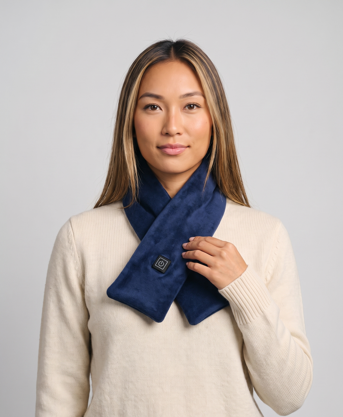 Woman wearing the USB heated scarf in pink, grey, red and black, with the button on the front of the scarf
