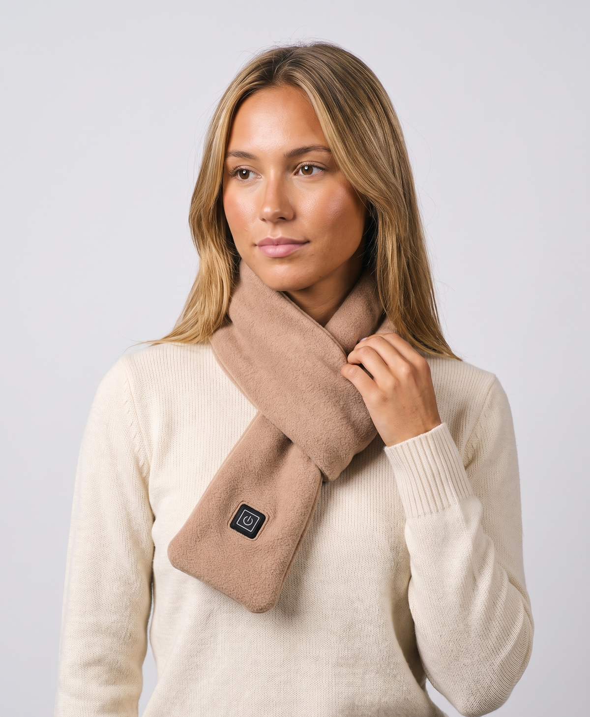 Woman wearing a light coffee USB heated scarf crossed at the neck, studio photo