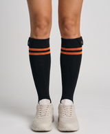 Pair of black striped heated cotton socks for women on a white background, showing the high cuff and heated foot area