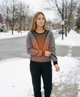 Lifestyle photo of a woman in the knitted sweater in a snowy winter setting