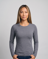 Gray women's long-sleeve crew-neck heated thermal top shown on a model, with a small heating icon patch at the lower side