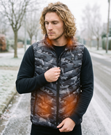 Men's camouflage heated vest shown for cold-weather outdoor wear, with the heating panels lit