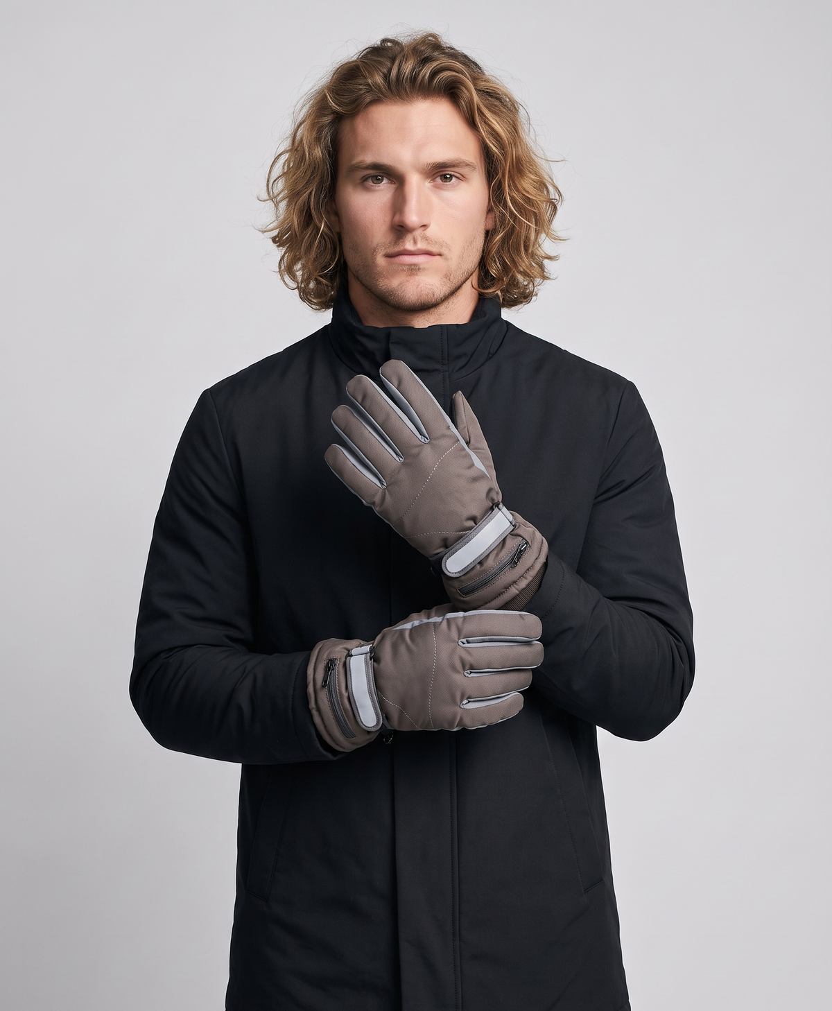Pair of men's grey rechargeable heated gloves with adjustable wrist strap and knitted cuff, studio photo