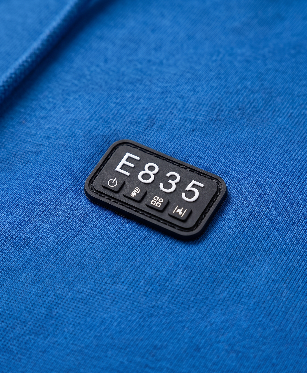 Close-up of the 4-button control panel on the chest of the sapphire blue heated hoodie