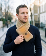 Lifestyle photo of the khaki heated neck scarf worn outdoors in winter weather
