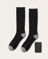 Black battery pack with red power button, shown beside the black knee-high heated socks it powers