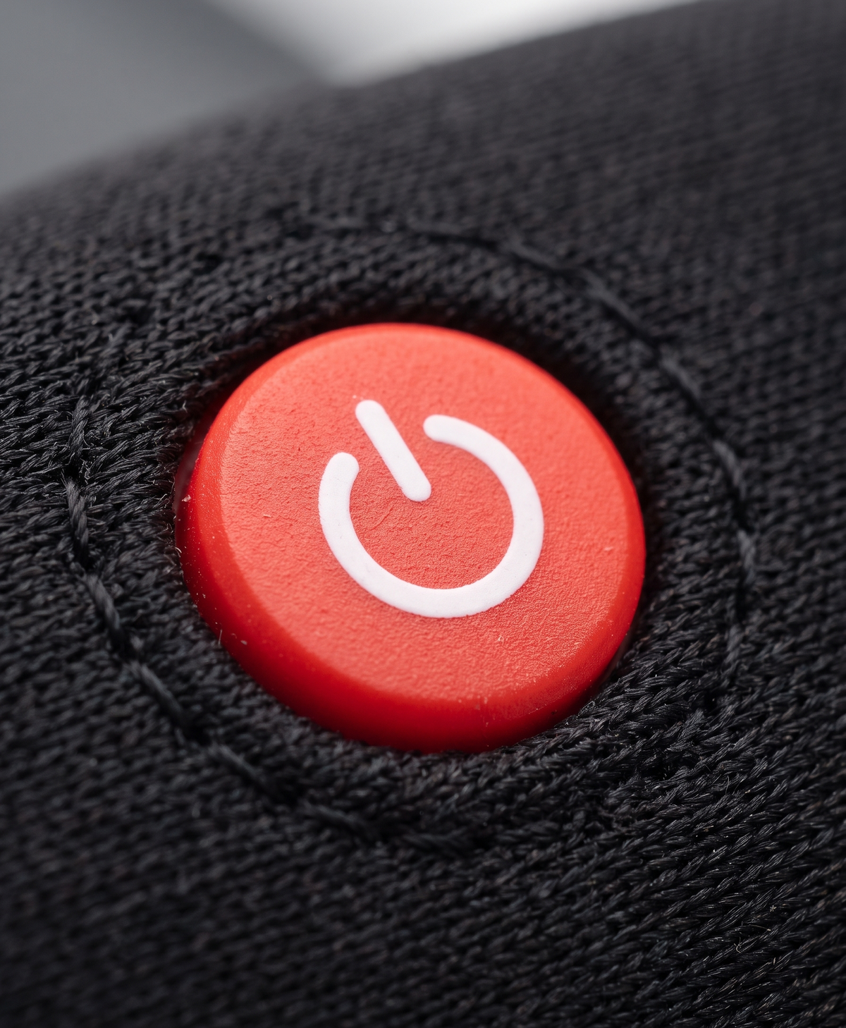 Close-up of the ribbed knit black heated sock cuff, with a contrasting heel and toe, and the battery pack