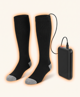 Black heated socks with the heating element and cable hidden inside, shown with the battery pack