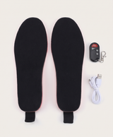 Black heated insoles with the wireless remote control and white charging cable on a white background