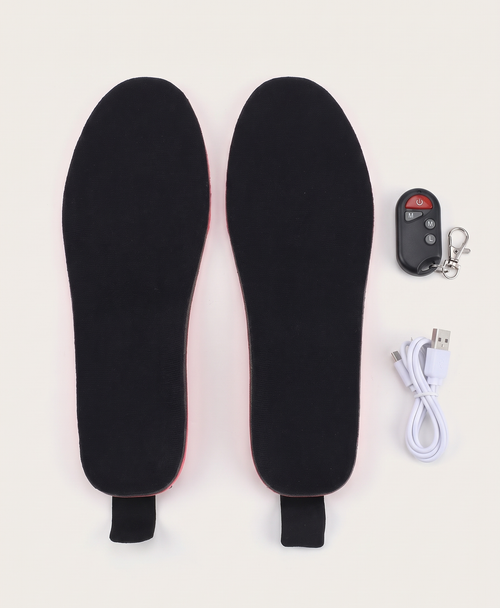 Black heated insoles with the wireless remote control and white charging cable on a white background