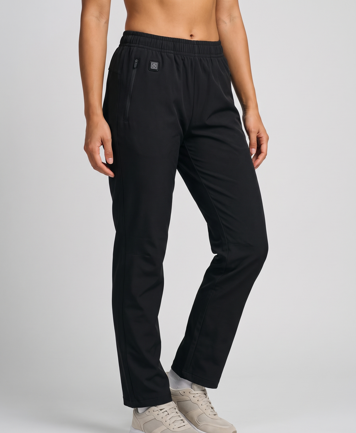 Model wearing black women's heated pants with elastic waist and white sneakers, with front and back heating zone views