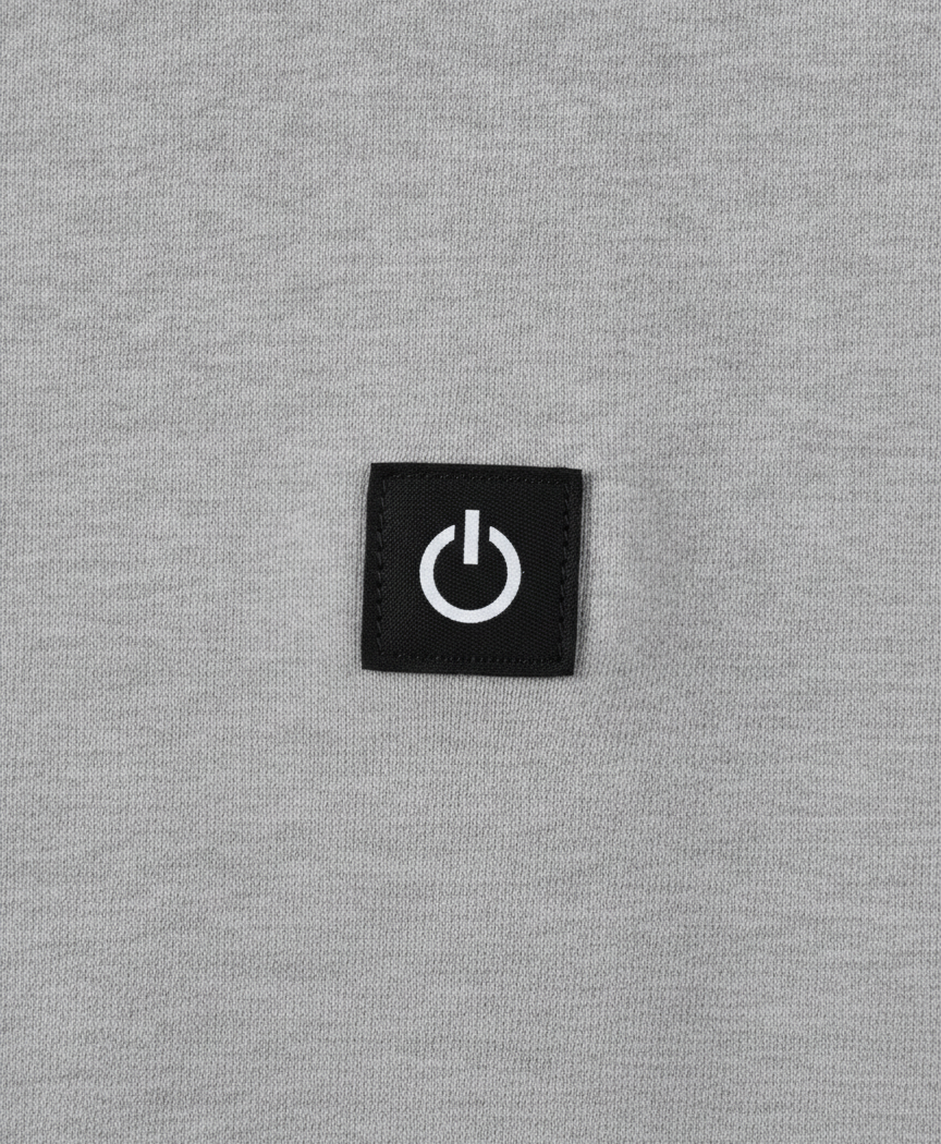 Close-up of the heated hoodie chest power button badge, drawstring hood and thick polyester fabric