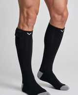 Pair of black knee-high heated socks for men with gray heel and toe, shown on a white studio background