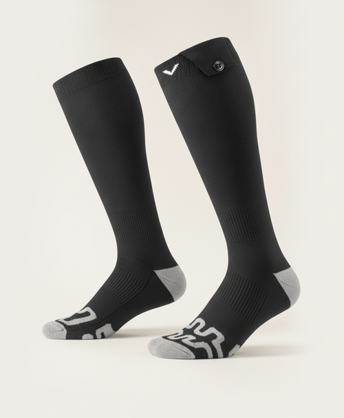Black knee-high heated socks with gray heel and toe and a button flap at the cuff, product photo