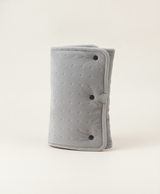 Gray quilted-dot crystal soft heated hand muff with three buckles, rolled up next to its black USB cable