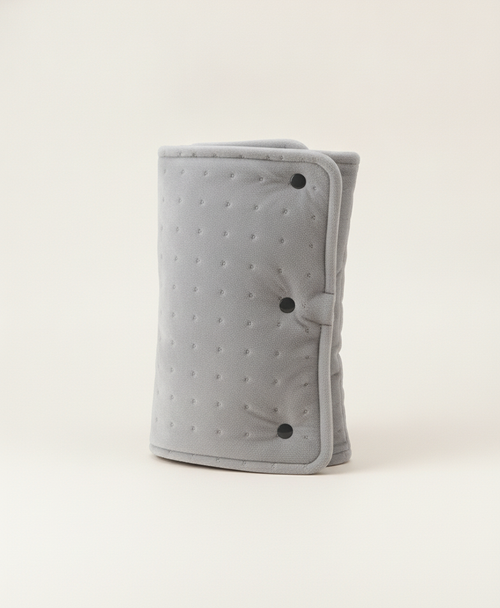 Gray quilted-dot crystal soft heated hand muff with three buckles, rolled up next to its black USB cable