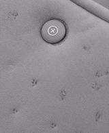 Close-up of the gray embossed soft fabric and buckles on the heated hand muff, with the USB cable attached