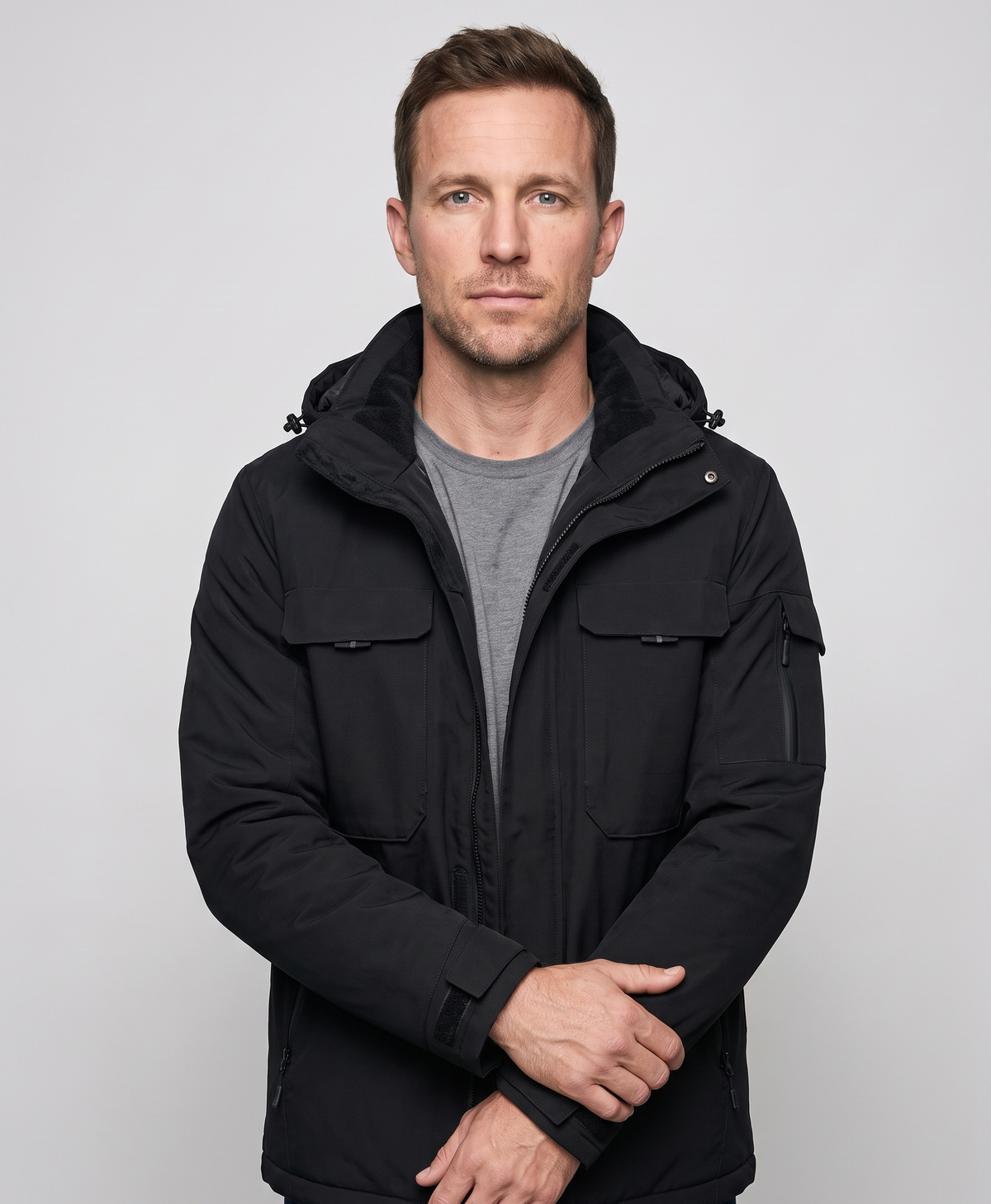 Men's black heated jacket with hood, seen from the back, studio product photo