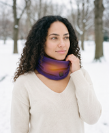 Purple fleece heated neck gaiter worn outdoors in a snowy mountain setting, lifestyle photo