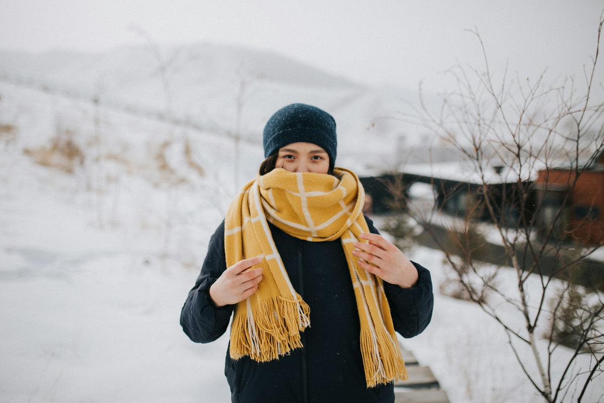 Coziva hero women - woman in a knit cap and black jacket in the snow